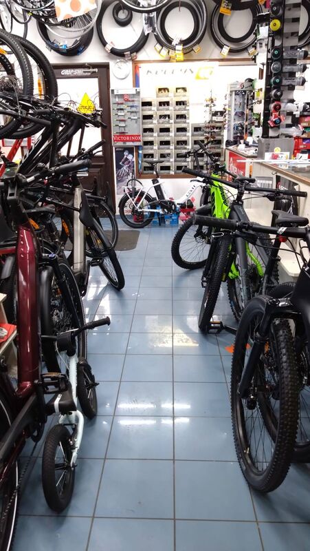 Interiér prodejny s řadami kol a příslušenstvím